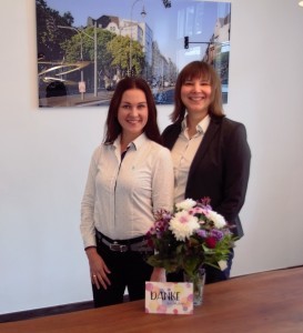 Rechtsanwältinnen mit Blumen und Dankeskarte